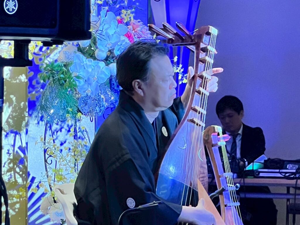 会場を包む琵琶の音色と、演奏に集中する荒井さんの表情。