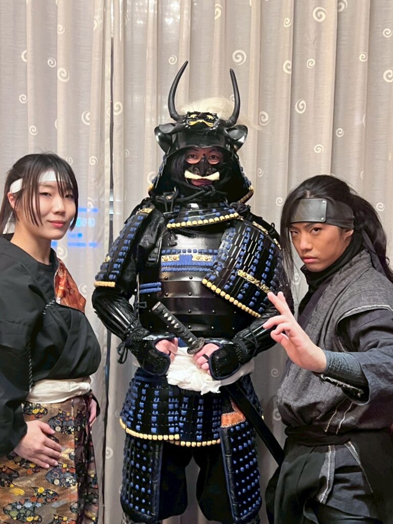 甲冑姿の武将と忍者衣装のパフォーマーが並んで撮影した集合写真